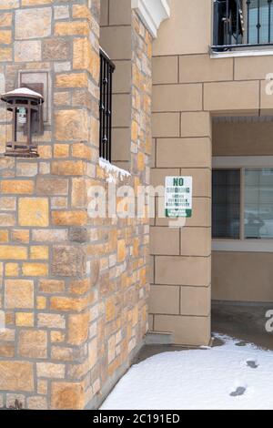 Außenansicht der Apartments mit Rauchverbot-Schild an der Steinmauer Stockfoto