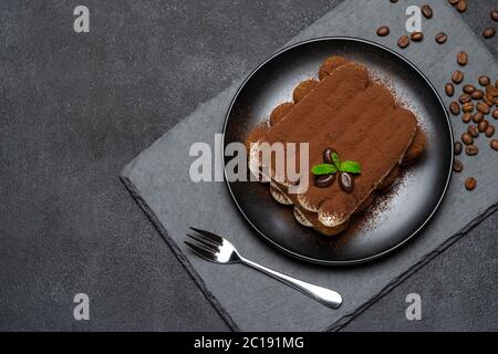 Klassisches Tiramisu Dessert auf Keramikplatte auf Betongrund Stockfoto