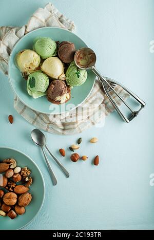 Set von weichen Eisschaufeln in verschiedenen Geschmacksrichtungen mit Schokolade und Nüssen Stockfoto