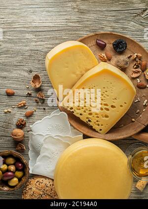 Auswahl an Käse, Wein, Nüssen und Früchten auf einem Holztisch. Draufsicht. Freier Speicherplatz für Text. Stockfoto