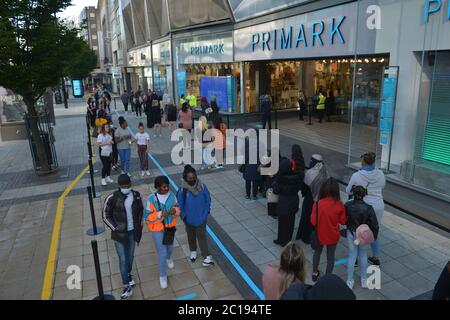 Einkäufer stehen bei Primark in Birmingham als nicht-wesentliche Geschäfte in England Schlange und öffnen ihre Türen zum ersten Mal seit der Verhängung von Sperrbeschränkungen durch Coronavirus im März. Stockfoto