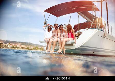 Gruppe lächelnder Freunde, die auf der Yacht reisen und Spaß haben. Stockfoto