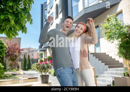 Junges Paar hält die Schlüssel von zu Hause und fühlt sich aufgeregt Stockfoto