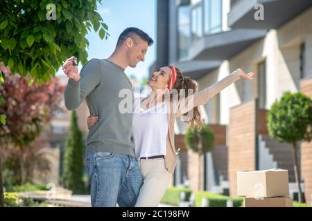 Glückliches junges Paar, das sich nach dem Umzug in ein neues Haus erstaunlich fühlt Stockfoto