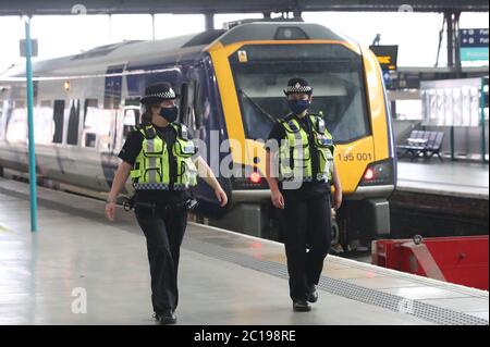 Polizeibeamte mit Gesichtsmasken am Bahnhof von Leeds, da Gesichtsbedeckungen für öffentliche Verkehrsmittel in England obligatorisch werden, da während der Coronavirus-Pandemie weitere Sperrbeschränkungen aufgehoben werden. Stockfoto