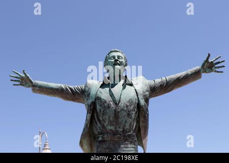 Bronzestatue, die dem italienischen Sänger Domenico Modugno auf der Promenade von Polignano a Mare, Apulien, Italien gewidmet ist Stockfoto