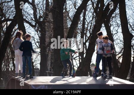 Lviv, Ukraine - 12. März 2020: Kinder fahren auf dem Roller im Skatepark. Kind hat Spaß mit Roller Stockfoto