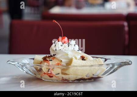 Eis in einer Bootsplatte mit Banane und Kirsche verziert. Stockfoto
