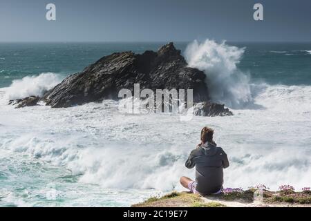 Ein Tourist, der die dramatische Aussicht von Pentire Point East an der Küste von Newquay in Cornwall genießt. Stockfoto