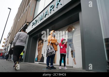 Die Käufer tragen Gesichtsmasken in der Warteschlange für den Primark Store in der Northumberland Street, Newcastle, da nicht unbedingt erforderliche Geschäfte in England ihre Türen zum ersten Mal öffnen, seit Coronavirus-Sperrbeschränkungen im März verhängt wurden. Stockfoto