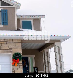 Quadratische Ernte Home Fassade mit festlichen Weihnachtskränze und bunten String Lichter im Winter Stockfoto