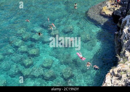 Badegäste und Touristen am berühmten Strand Lama Monachile in Polignano a Mare, Apulien, Italien Stockfoto