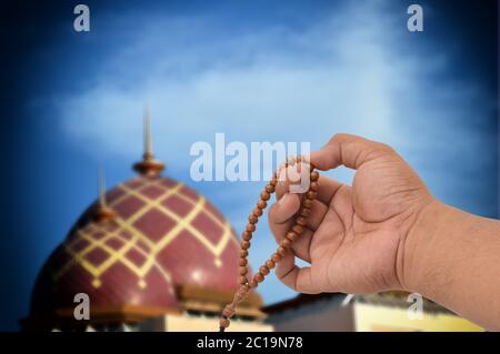 Muslimische männliche Hände halten Rosenkranz Stockfoto