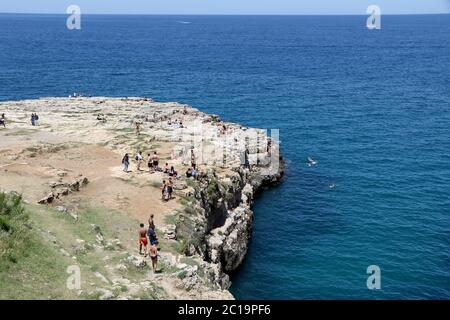 Badegäste und Touristen am berühmten Strand Lama Monachile in Polignano a Mare, Apulien, Italien Stockfoto