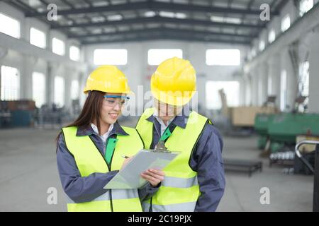 Junge asiatische Mann und Frau arbeiten in der Werkstatt Stockfoto