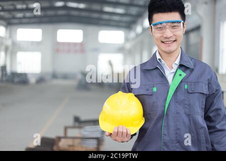 Junger asiatischer Mann arbeitet in der Werkstatt Stockfoto