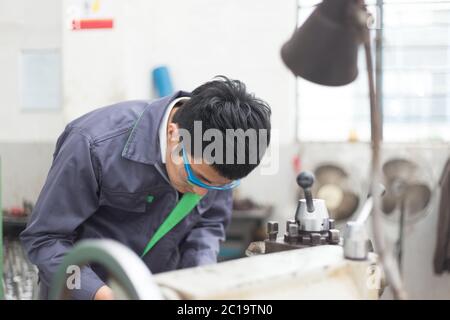 Junger asiatischer Mann arbeitet in der Werkstatt Stockfoto
