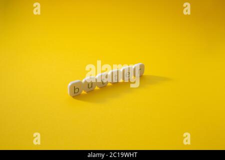 Alphabet Butter Wortblock mit gelbem Hintergrund. Stockfoto