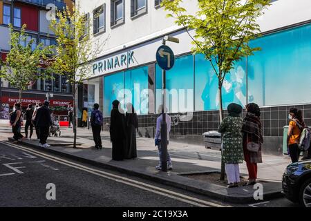 Wembley Central, London, Großbritannien. Juni 2020. Die Einkäufer stehen an der Wembley High Road mit den sozial weit entfernten 2-Meter-Markierungen vor Primark. Coronavirus Covid-19 Sperrbeschränkungen erlauben nicht unbedingt notwendige Geschäfte, heute wieder zu öffnen. Chris Aubrey/Alamy Live News Stockfoto