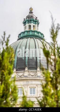 Vertikale majestätische Kuppel des Utah State Capital Building mit verschwommenen Bäumen im Vordergrund Stockfoto