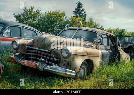 Vintage rostigen Retro-Auto unter anderem Autos in grünem Gras. Stockfoto