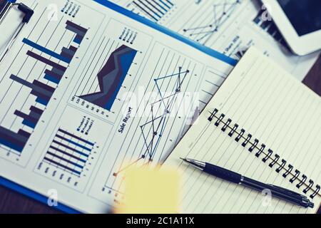Brille, Buch, Papiergraph und Tablet auf dem Tisch. Gegenstand des Geschäftskonzepts. Stockfoto
