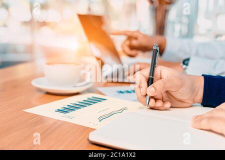 Geschäftsmann Hand schreiben Notiz auf einem Notizbuch. Geschäftsmann, der am Schreibtisch arbeitet. Stockfoto