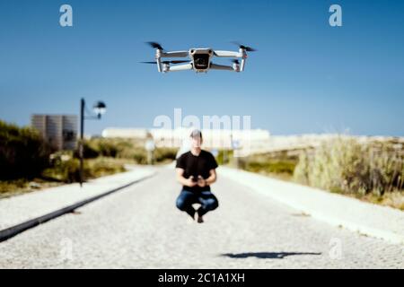Mann hält Remote fliegen zusammen mit seiner Drohne in erster Linie Stockfoto
