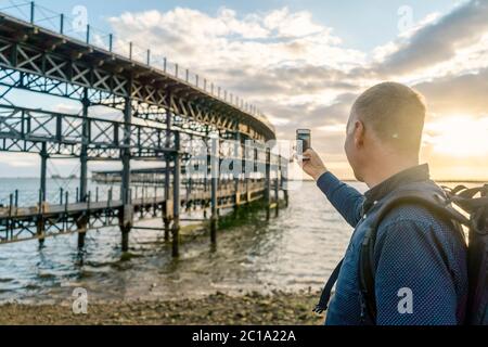 Tourist fotografiert den historischen Rio Tinto Pier bei Sonnenuntergang in Huelva, Andalusien, Spanien Stockfoto