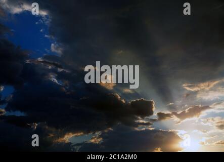 Ein gefährlicher Himmel voller Sturmwolken, die Sonne bricht durch die Wolken. Stockfoto