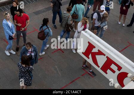 Moskau, Russland. 14. Juni 2020 Menschen stehen in der Schlange, um sich sozial zu distanzieren, im KFC-Schnellrestaurant auf dem Manezhnaya-Platz in Moskau während der neuartigen Coronavirus-Epidemie (COVID-19) in Russland Stockfoto