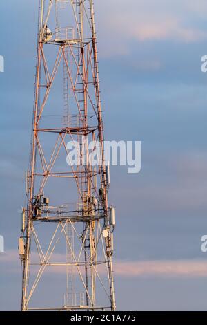 5g 6g Mobilfunkturm auf der Straße vor dem Hintergrund blauer Wolken Stockfoto