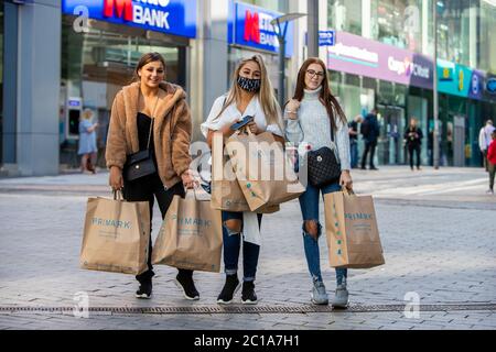 Birmingham, Großbritannien. Juni 2020. Eine Gruppe von Freunden verlässt Primark (den weltweit größten Primark-Laden) mit ihren Einkäufen. Sie hatten draußen auf das Geschäft gewartet, das ab 4 Uhr morgens geöffnet hatte. Nach mehreren Wochen der Schließungen während der Covid-19-Sperre dürfen nicht-wesentliche Geschäfte innerhalb Englands wieder geöffnet werden. Covid-Sicherheitsrichtlinien wurden eingeführt, um ein möglichst sicheres Einkaufserlebnis zu gewährleisten. Es wird gehofft, dass dies der Beginn einer wirtschaftlichen Erholung sein wird. Kredit: Anthony Wallbank/Alamy Live Nachrichten Stockfoto