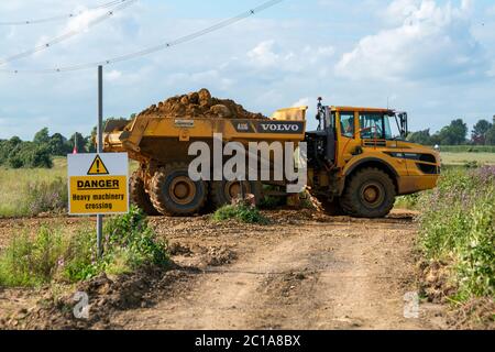 Ein voll beladener Muldenkipper überquert einen Feldweg, der als Brückenweg genutzt wird. Um es 's Last von Phase eins zu Phase zwei zu dumpen, um die Minenwände zu bauen. Stockfoto