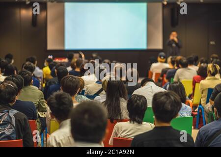 Rückansicht des asiatischen Publikums, der mit dem Sprecher auf der Bühne im Seminarkonferenzraum oder im Konferenzsaal, in der Ausbildung und im Workshop spricht, Stockfoto