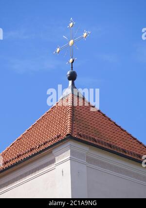 Goldenes Kreuz auf rotem Ziegeldach Stockfoto