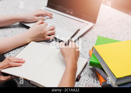 Nahaufnahme der Hände der Frau halten Stift und Schreiben in Notizblock Stockfoto