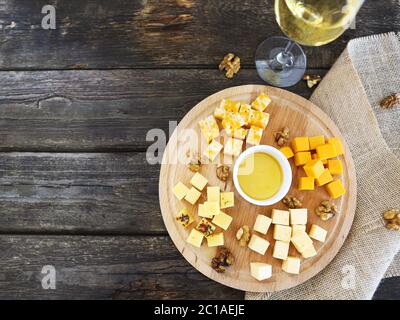 Einstellen von verschiedenen Käsesorten mit einem Glas Weißwein auf dem hölzernen Tisch Stockfoto