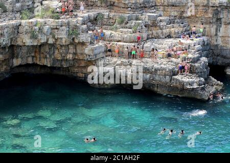 Badegäste und Touristen am berühmten Strand Lama Monachile in Polignano a Mare, Apulien, Italien Stockfoto