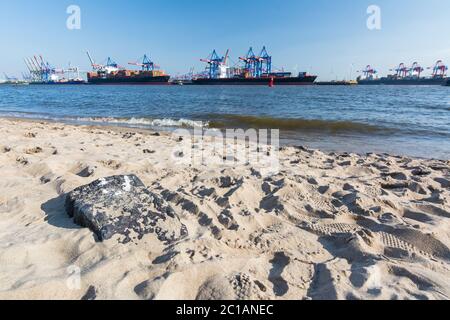 Elbestrand mit Containerterminal und Schiffen im Hintergrund in Hamburg Stockfoto