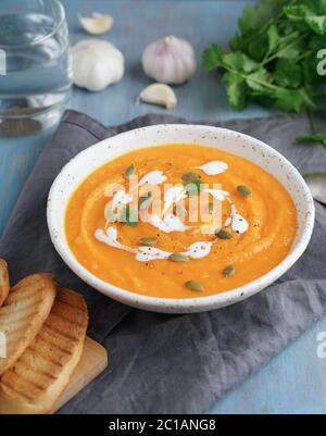 Puppmkin Sahne Suppe Püree, diätetische vegetarische Mittagessen auf blauen Holztisch Stockfoto