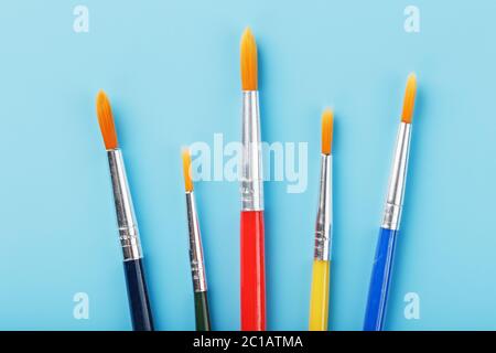 Mehrfarbige Pinsel für Zeichnung und Kunst auf blauem Hintergrund. Stockfoto