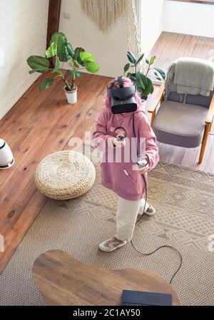 Hipster teen Mädchen tragen vr Headset spielen virtuelle Realität Spiel, oben vertikale Ansicht. Stockfoto
