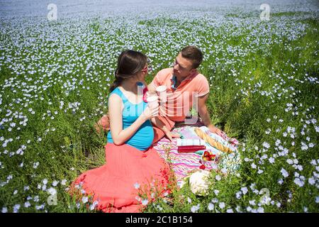 Junge glücklich Schöne schwangere Paare in Leinen Feld Stockfoto