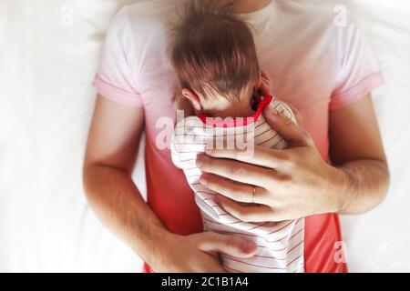 Schöner Vater hält seine schlafende neugeborene Tochter Stockfoto