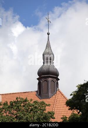 Goldenes Kreuz auf rotem Ziegeldach Stockfoto