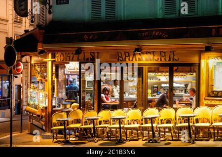 Paris ruhiger Moment mit einem Buch in der Wärme einer Brasserie, Frankreich. Stockfoto