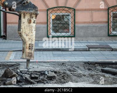 Presshammer auf einem Renovierungsfahrzeug montiert, mit einem pneumatischen Bohrer perforiert den Asphalt einer städtischen Straße, die auf einer Straßenkonstruktion s renoviert wird Stockfoto