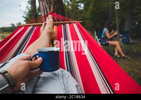 Mann ruht auf Hängematte in Waldsommerzeit Stockfoto