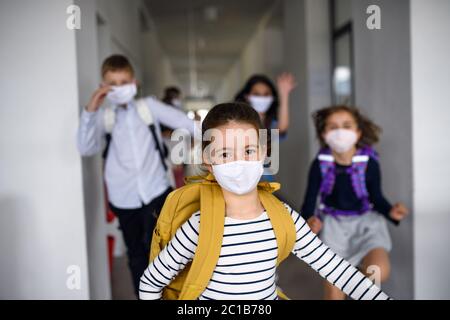 Gruppe von fröhlichen Kindern nach der Schule nach Covid-19 Quarantäne und Sperrung nach Hause gehen. Stockfoto